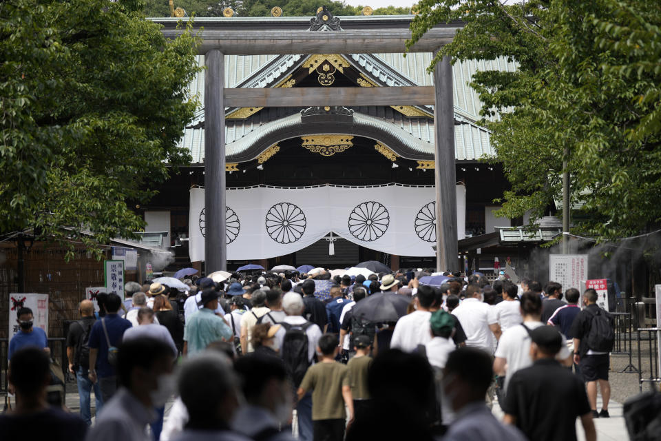 People queue to pay respects to the war dead at Yasukuni Shrine Monday, Aug. 15, 2022, in Tokyo. Japan marked the 77th anniversary of its World War II defeat Monday. (AP Photo/Eugene Hoshiko)
