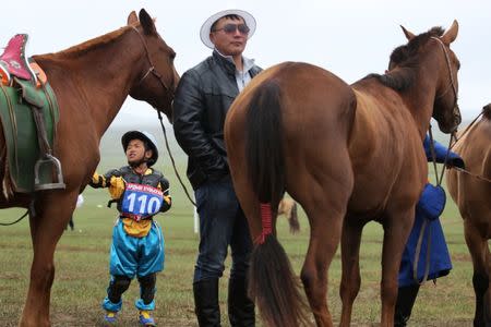 Child jockey Usukhbayar Otgonbayar, 11, waits for his horse trainer, or uyach, to do the send-off ceremony at the Mongolian traditional Naadam festival, on the outskirts of Ulaanbaatar, Mongolia July 11, 2018. Picture taken July 11, 2018. REUTERS/B. Rentsendorj