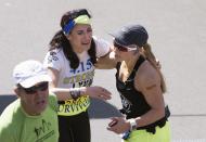 Boston Marathon bombing victim Lynn Crisci (C) reacts after finishing the 118th running of the Boston Marathon with Sarah Reinertsen (R) in Boston, Massachusetts, April 21, 2014. REUTERS/Gretchen Ertl (UNITED STATES - Tags: SPORT ATHLETICS)