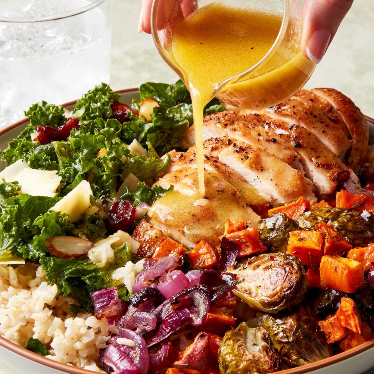 chicken, kale salad, and roasted sweet potatoes in a rice bowl