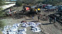 Rescue workers collect bodies from the burnt wreckage of a bus accident in Bela, an area of Lasbela district of Balochistan province, Pakistan, Sunday, Jan. 29, 2023. The passenger bus crashed into a pillar and fell off a bridge, catching fire and killing dozens of people in southern Pakistan on Sunday, a government official said. (AP Photo/Muhammad Saleem)