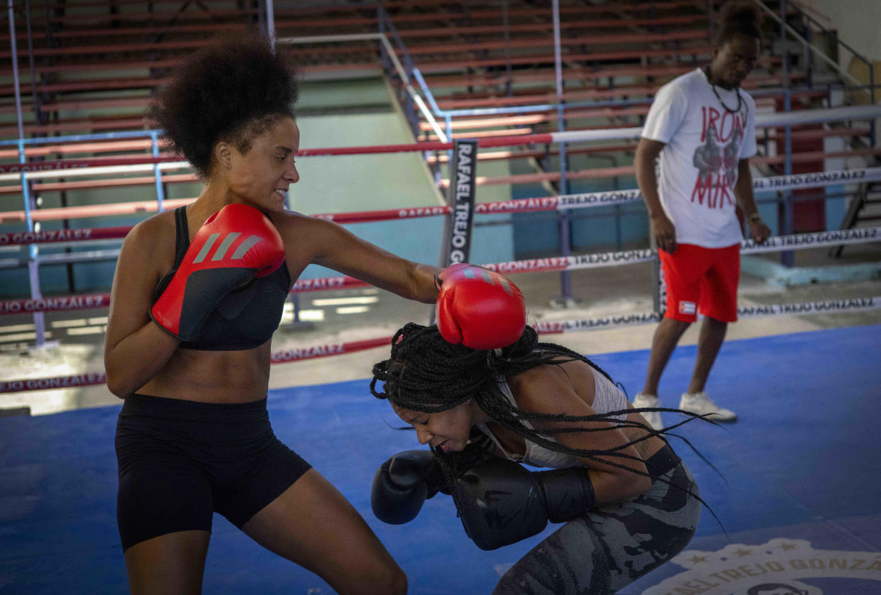 Boxer Giselle Bello Garcia, left, throws a punch at Ydamelys Moreno during a training session in Havana, Cuba, Monday, Dec. 5, 2022. Cuban officials announced on Monday that women boxers would be able to compete for the first time ever. (AP Photo/Ramon Espinosa)