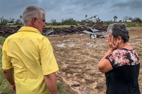 Tobacco farm owner Maritza Carpio cries next to her husband Ramon Martinez while looking at their destroyed tobacco house after the passage of Hurricane Ian in San Luis, Cuba, on September 27, 2022. - 