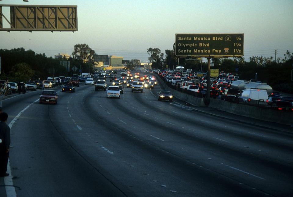 Police cars pursue the Ford Bronco driven by Al Cowlings, carrying fugitive murder suspect O.J. Simpson, on a 90-minute slow-speed car chase June 17, 1994 on the 405 freeway in Los Angeles. (Getty)