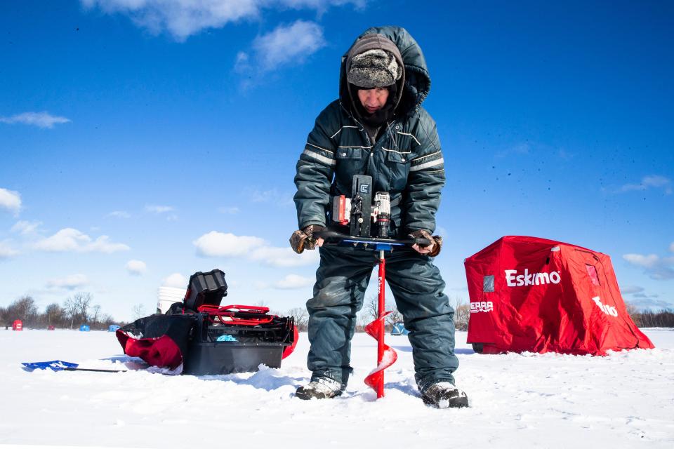 Angler Art Blum, from Erie, drills a fishing hole on his favorite spot with an electric auger, on Jan. 25, 2022, at Presque Isle State ParkÕs Misery Bay. Recent cold weather has produced about five inches of ice on Misery Bay.