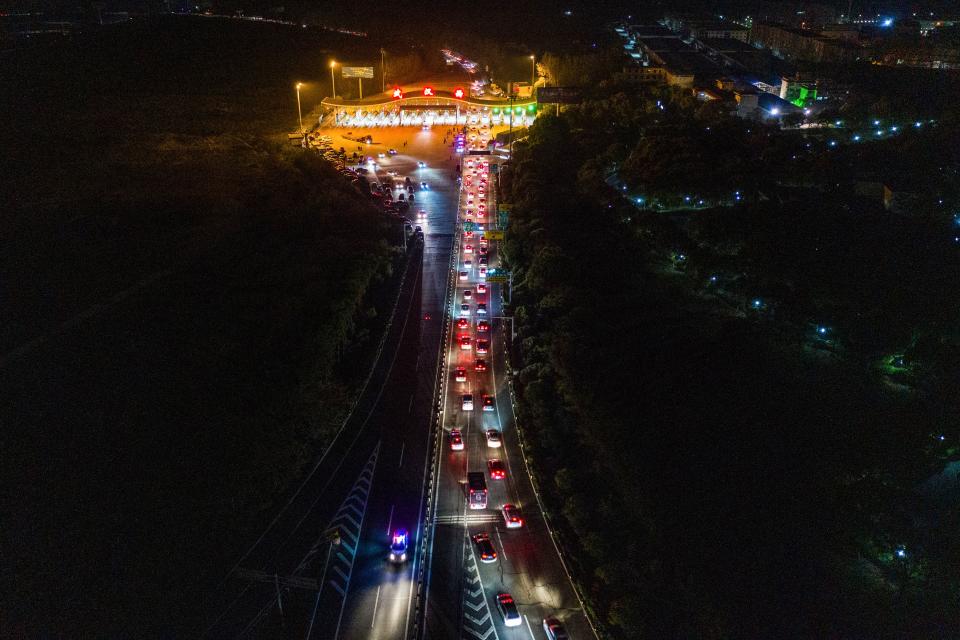 This aerial photo taken early on April 8, 2020 shows cars queueing at a highway toll station in Wuhan in China's central Hubei province, as they prepare to leave the city after authorities lifted a more than two-month ban on outbound travel. - Thousands of Chinese travellers rushed to leave COVID-19 coronavirus-ravaged Wuhan early on April 8 as authorities lifted a more than two-month prohibition on outbound travel from the city where the global pandemic first emerged. (Photo by STR / AFP) / China OUT (Photo by STR/AFP via Getty Images)