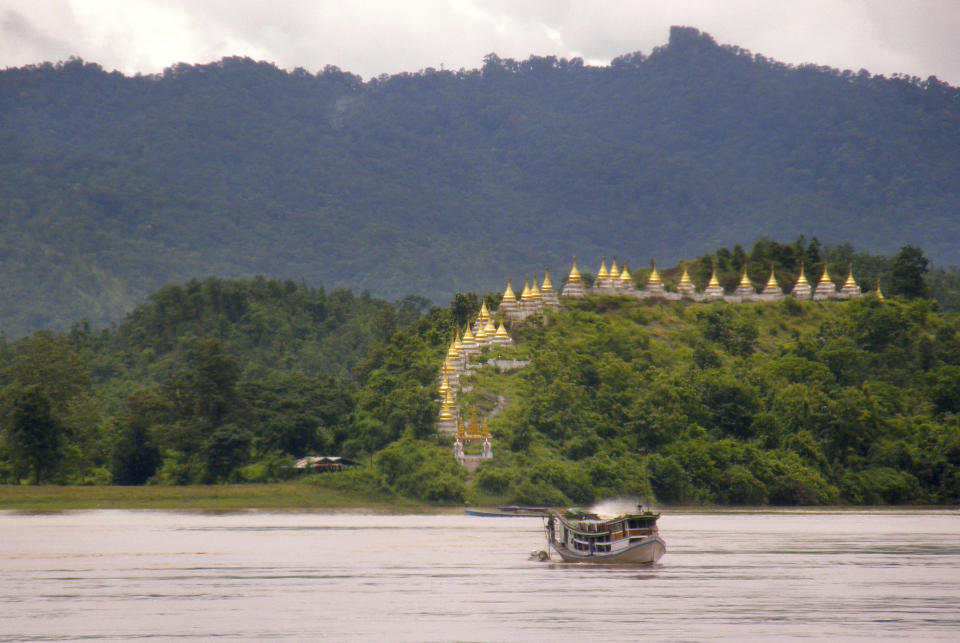 In this July 30, 2013 photo, golden spires of Massein monastery are seen on the banks of Myanmar's upper Chindwin river. As the country emerges from decades of isolation, these are among the sights being discovered for the first time by foreign tourists traveling aboard the luxury Orcaella cruise ship. (AP Photo/Cynthia NeJame)