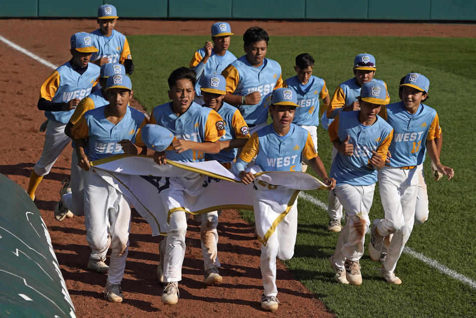 Honolulu takes a victory lap in Lamade Stadium after defeating Curacao 13-3 in four innings in a Little League World Series Championship game in South Williamsport, Pa., Sunday, Aug. 28, 2022. (AP Photo/Gene J. Puskar)