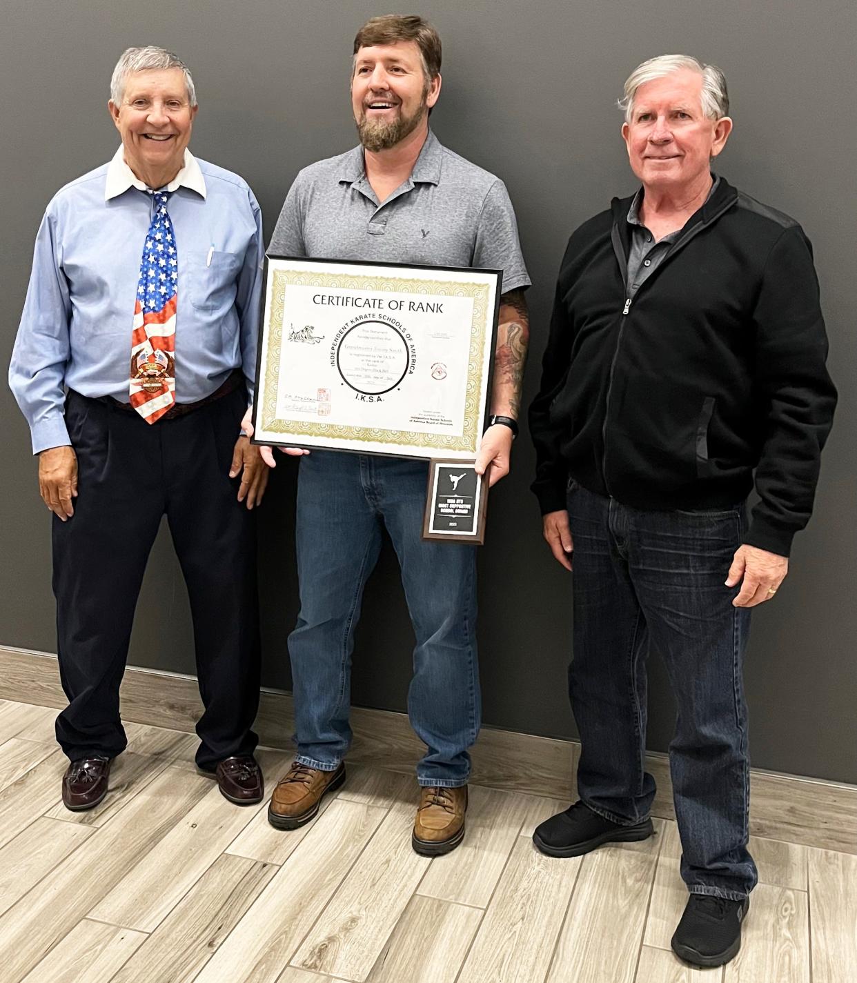 James C. Smith II, center, also known as "Mr. Jimmy," receives a certificate of rank for earning his 9th Dan (degree) Black Belt in Tae Kwon Do. At left is 10th Dan Grandmaster Danny Chapman, president of the Independent Karate Schools of America Association, and at right is 10th Dan Grandmaster Floyd Burk, director of the IKSA and editor of Black Belt Magazine.