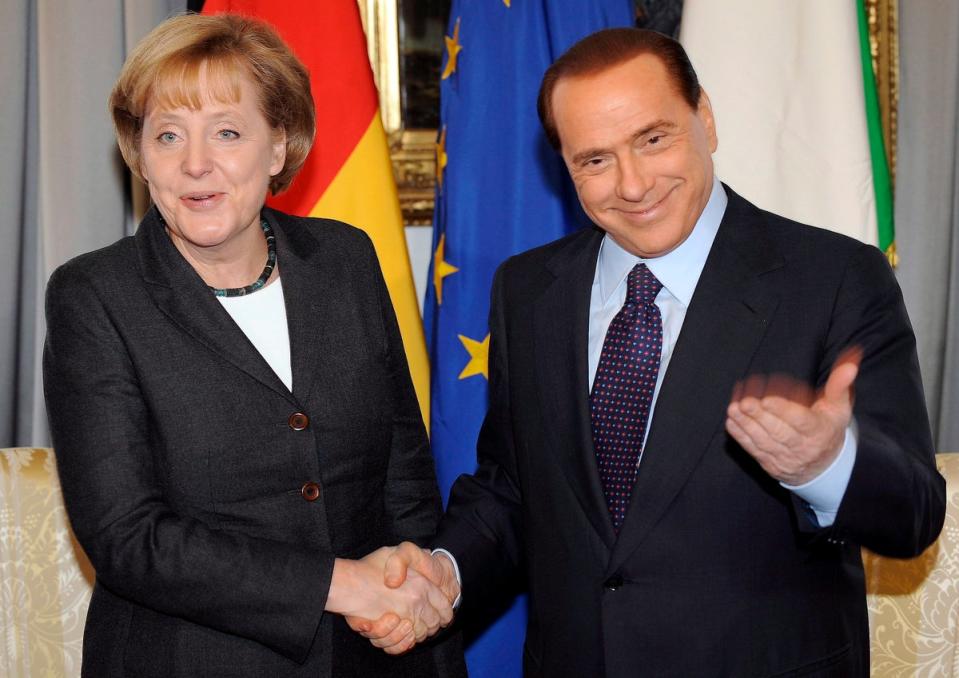 Berlusconi and German chancellor Angela Merkel shake hands during the 2008 Italy-Germany summit in Trieste (EPA)