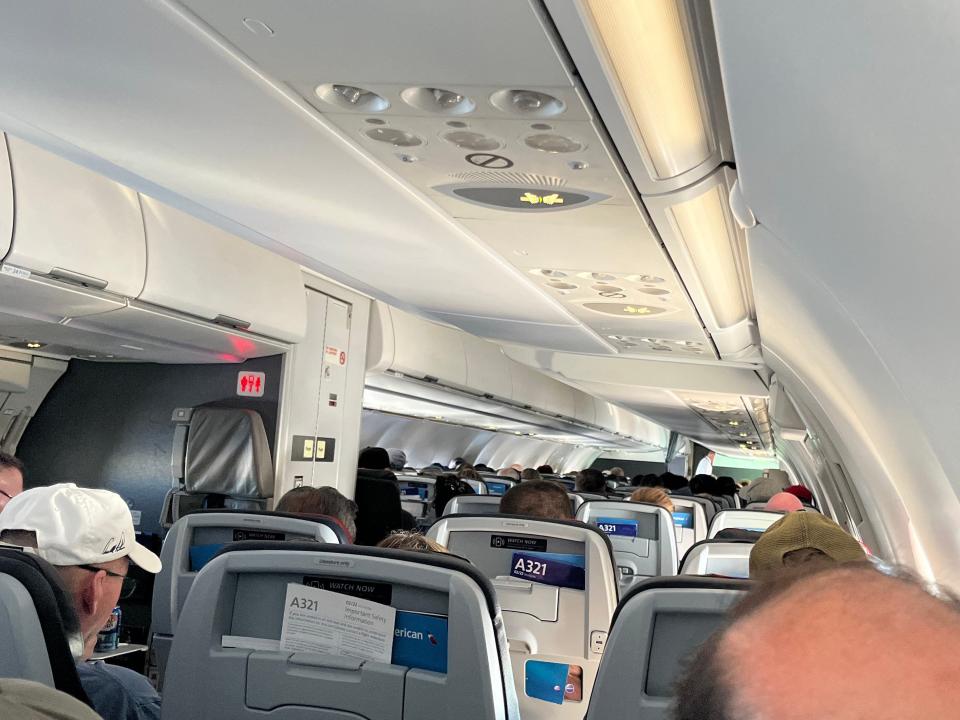 A group of passengers sitting on an American Airlines flight.