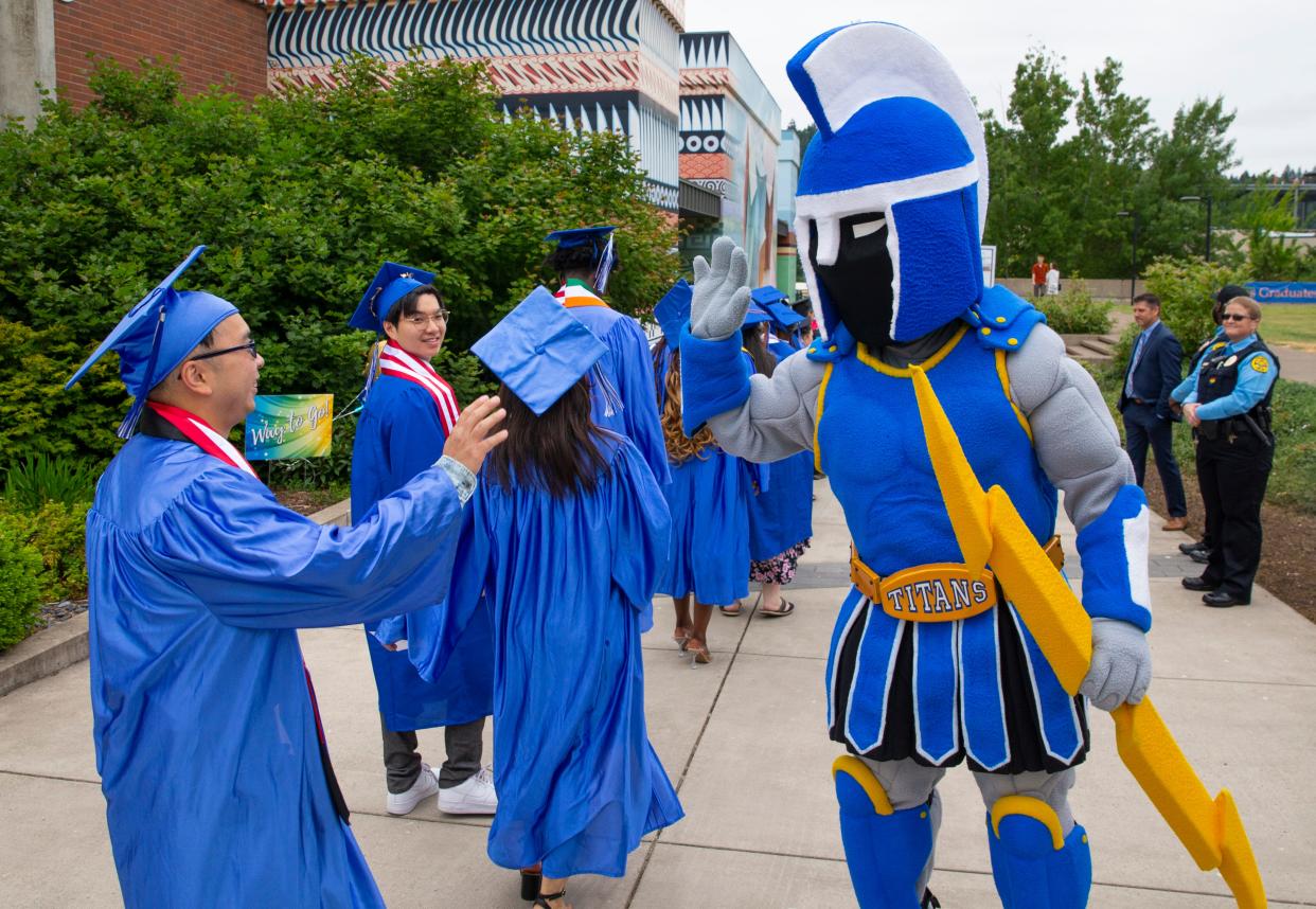 Ty the Titan congratulates graduates June 17 as they enter the gym at Lane Community College for their commencement ceremony. The community college's enrollment numbers are just beginning to recover from declines during the peak of the pandemic, but remain far below where they were more than a decade ago.