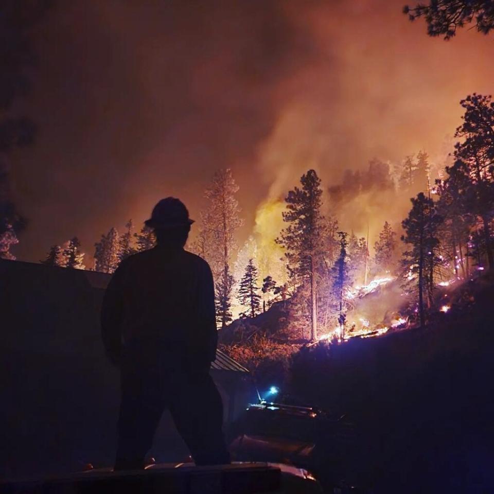 A firefighter looks at the Hermits Peak-Calf Canyon fire on a recent night. The prescribed burn that escaped has echoes of the Cerro Grande, which in 2000 became a cautionary tale in a new prescribed burn regime.
