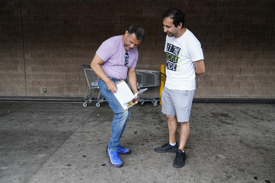 FILE - Gabriel Sanchez, right, talks with Atlanta resident, Bobby Thornton, left, Thursday, July 20, 2023, in Atlanta. Activists with the Stop Cop City Vote Coalition collected signatures to force a referendum allowing voters to decide the fate of a proposed police and firefighter training center. But an analysis of petition entries by four news organizations finds it’s unclear whether petitioners have enough valid entries to force the citywide vote, with nearly half the entries unable to be matched to eligible registered Atlanta voters. (AP Photo/Brynn Anderson, file)