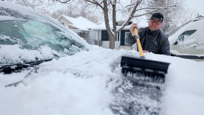 Jason Robichaud clears snow off his truck during a snowstorm in Salt Lake City on Thursday, Jan. 11, 2024.