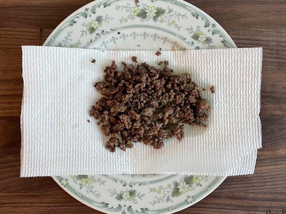 Ground beef on top of paper towel and a plate.
