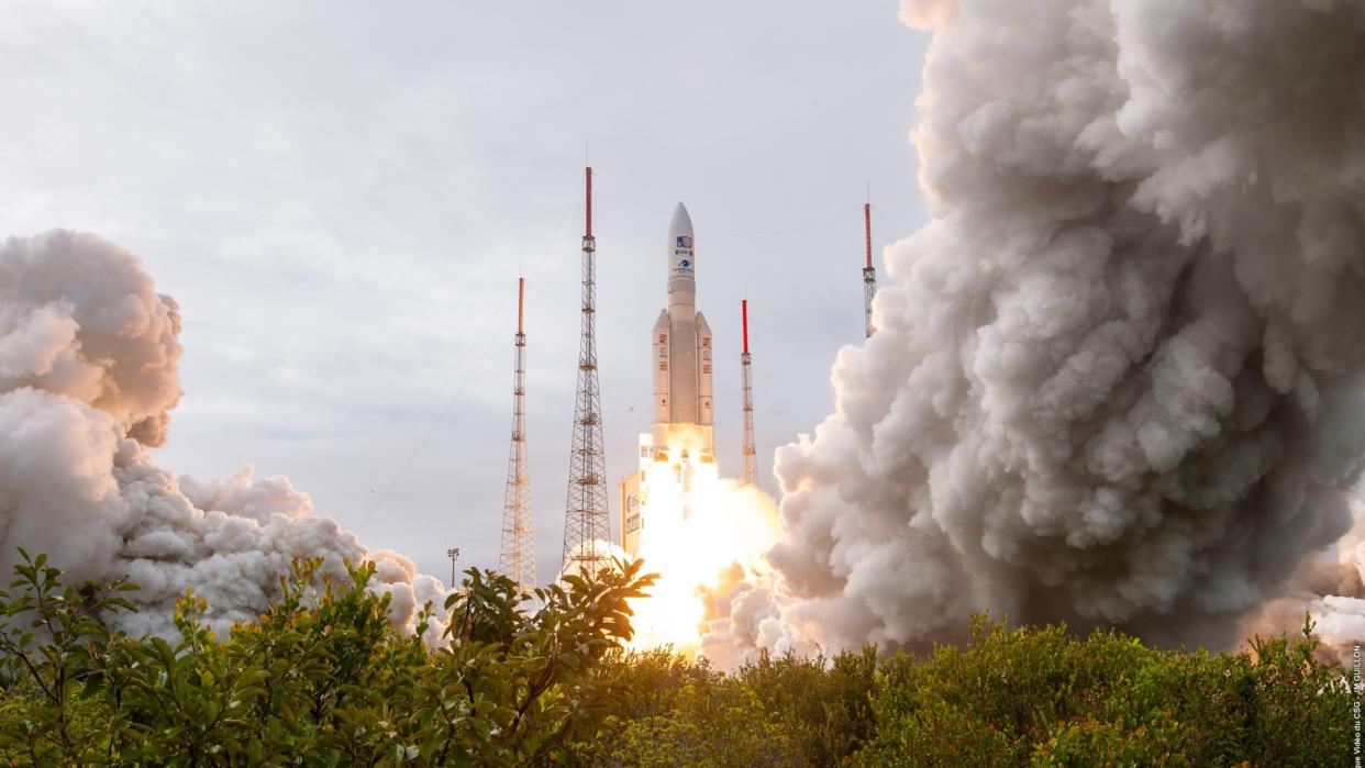  a rocket launches above trees 