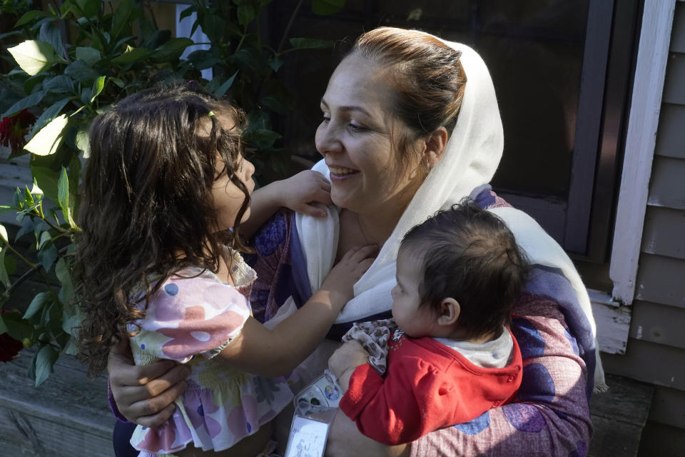 Mariam Walizada, center, who fled Afghanistan with her family, sits with two of her daughters Hasnat, left, and Kainat Amy, right, Thursday, Sept. 15, 2022, at their home, in Epping, N.H. Since the U.S. military's withdrawal from Kabul last year, the Sponsor Circle Program for Afghans has helped over 600 Afghans restart their lives in their communities. Now the Biden administration is preparing to turn the experiment into a private-sponsorship program for refugees admitted through the U.S. Refugee Admissions Program and is asking organizations to team up with it to launch a pilot program by the end of 2022. (AP Photo/Steven Senne)