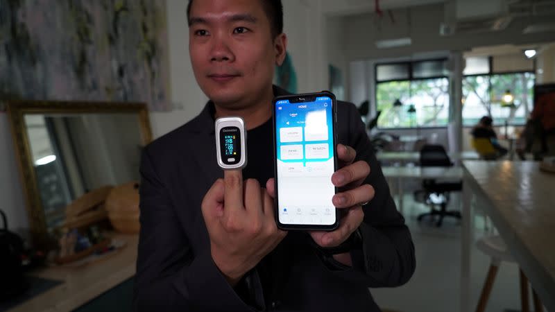 Nervotec founder Jonathan Lau shows the comparison in vital signs readings between his company's app and a pulse oxygen monitor, in Singapore