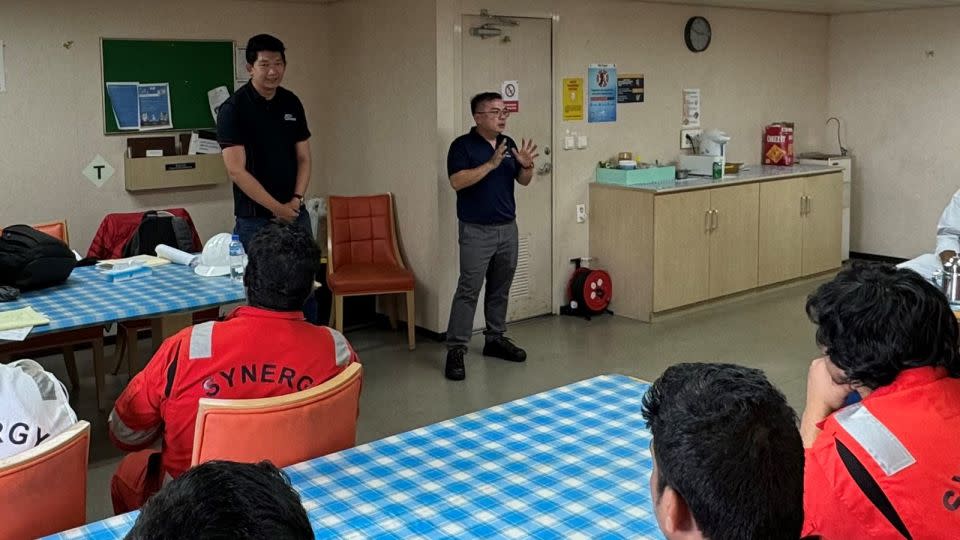 From left: Bro Chen Chuanyi, executive secretary of the Singapore Organisation of Seamen, and Gwee Guo Duan, assistant general secretary of the Singapore Maritime Officers’ Union, speak with seamen aboard the Dali on April 24, four weeks after the cargo ship crashed into Baltimore's Key Bridge. - Singapore Maritime Officers’ Union/Singapore Organisation of Seamen/ITF