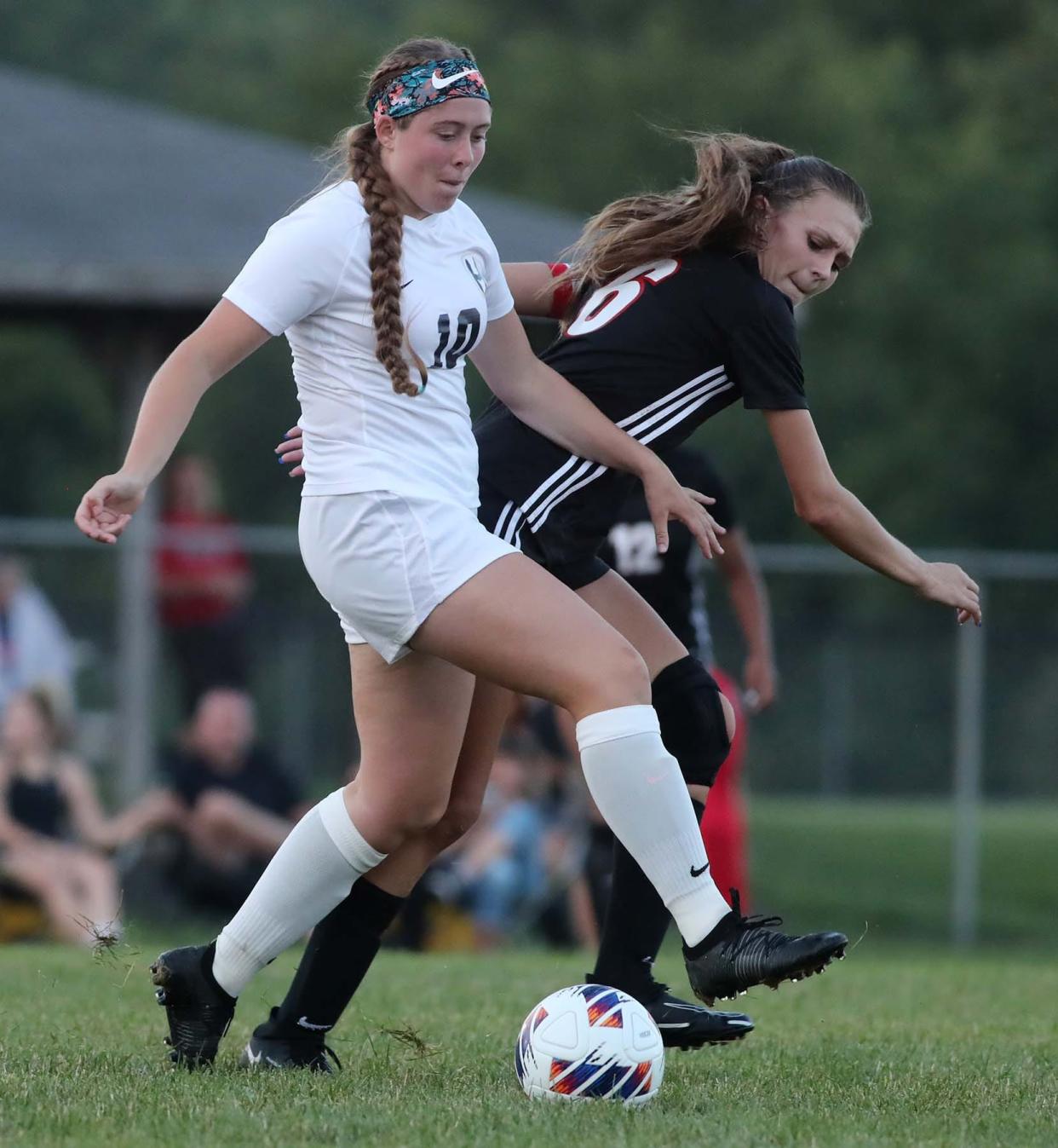 Carly Jones, left, of Hoban and Kennedy Boal of Manchester compete for the ball during the first half of a girls soccer match at Manchester High School in New Franklin on Monday.