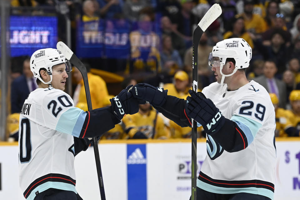 Seattle Kraken right wing Eeli Tolvanen (20) celebrates with defenseman Vince Dunn (29) after scoring a goal against the Nashville Predators during the first period of an NHL hockey game Saturday, March 25, 2023, in Nashville, Tenn. (AP Photo/Mark Zaleski)