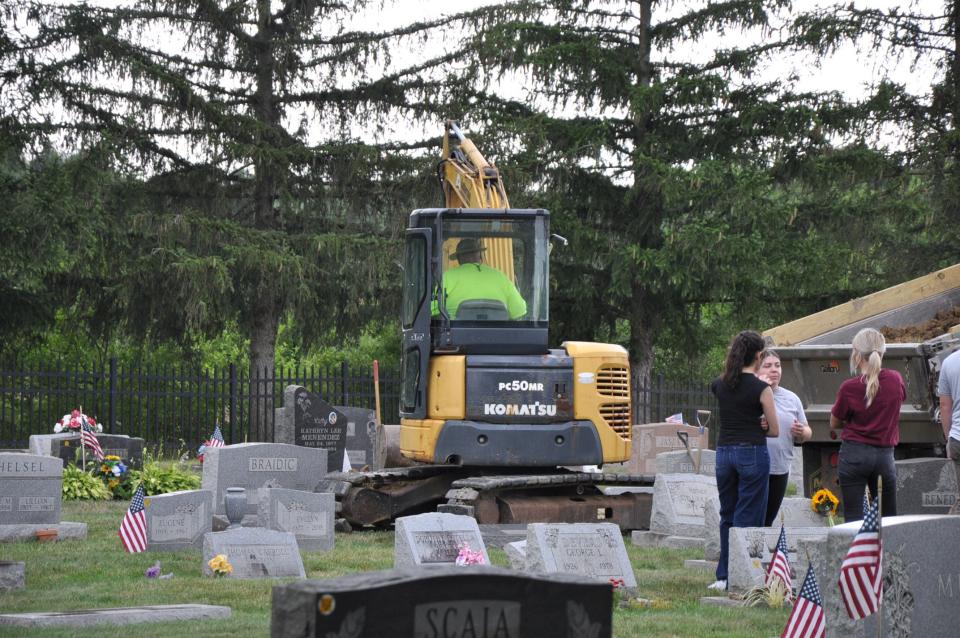 Remains of Kathryn Menendez, a murder victim in 1994, were exhumed Tuesday, June 25, 2024, by federal and local investigators at St. Joseph's Cemetery in Alliance. Her body was laid back to rest after DNA samples were obtained, and a cemetery worker, seen here, put dirt back on her grave.