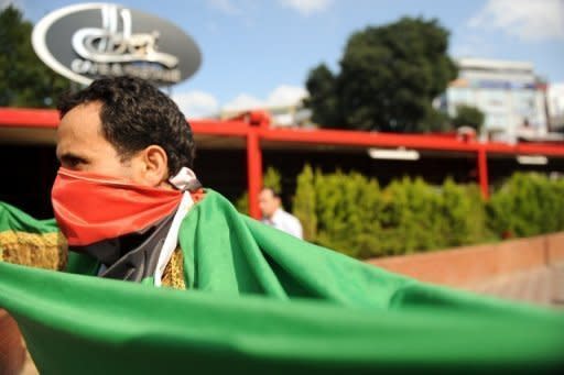 A man wears a Libyan flag over his mouth during a demonstration against Moamer Kadhafi in Istanbul. Western and regional powers have boosted Libyan rebels battling Moamer Kadhafi by designating them as the country's legitimate rulers, a move that gives them access to vital funds