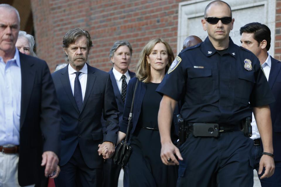 Felicity Huffman leaves federal court with her husband William H. Macy, left, and her brother Moore Huffman Jr., rear center, after she was sentenced in a nationwide college admissions bribery scandal, Friday, Sept. 13, 2019, in Boston. (AP Photo/Michael Dwyer)