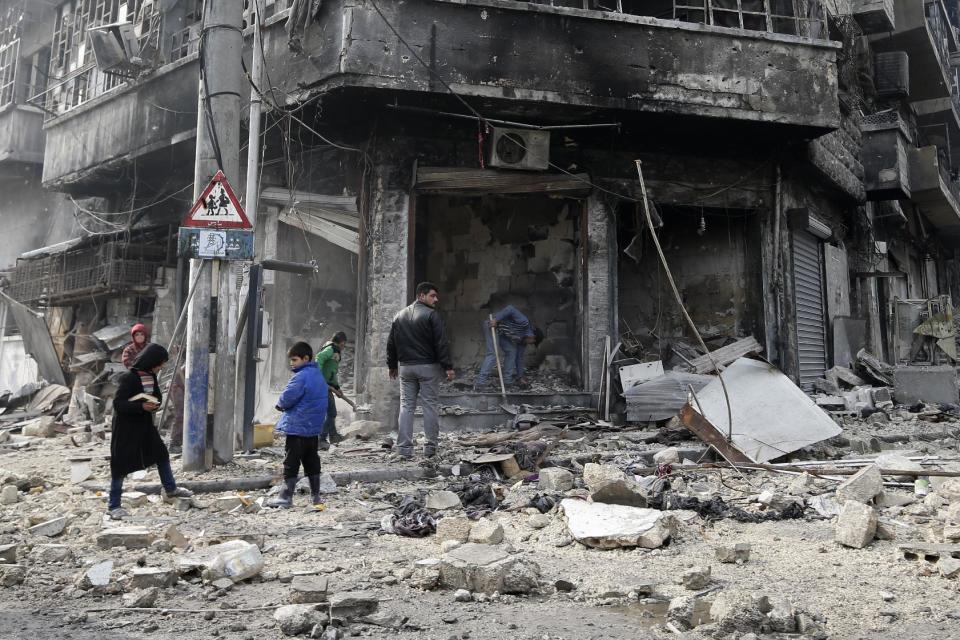 In this Jan. 20, 2017 photo, Syrian children remove rubble in the once rebel-held Bustan al-Qasr neighborhood in eastern Aleppo, Syria. Aleppo, Syria’s largest city, was widely brought to ruin by years of war, and now with Russia and Turkey leading peace efforts, international officials say it is time to start talking about rebuilding Aleppo and other cities. But there are few answers on how to do it, with the world reluctant to donate the billions needed and a political settlement in the war still uncertain and far off. (AP Photo/Hassan Ammar)