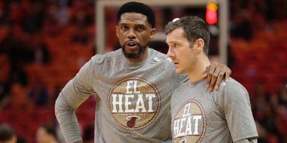 Udonis Haslem with his arm around the shoulder of Goran Dragic while standing on a basketball court