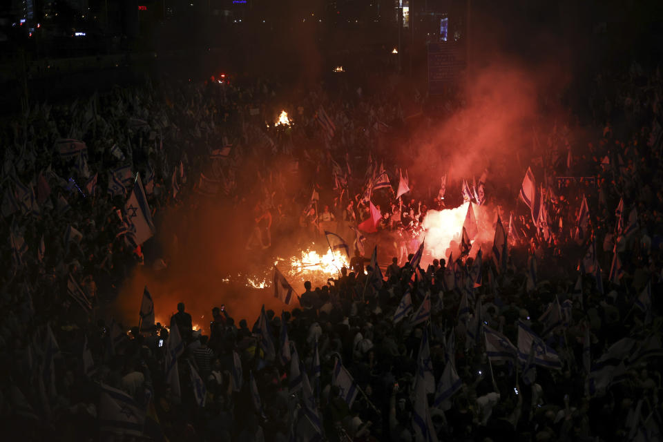 Israelis opposed to Prime Minister Benjamin Netanyahu's judicial overhaul plan set up bonfires and block a highway during a protest moments after the Israeli leader fired his defense minister, in Tel Aviv, Israel, Sunday, March 26, 2023. Defense Minister Yoav Gallant had called on Netanyahu to freeze the plan, citing deep divisions in the country and turmoil in the military. (AP Photo/Oren Ziv)