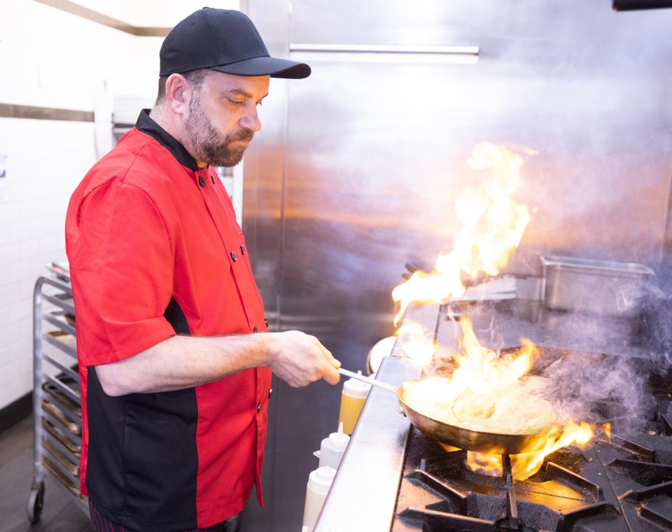 A favorite seasonal starter, Chef Jeff Herman puts some char on shishito peppers for a customer order at Social at the Stone House in Massillon.