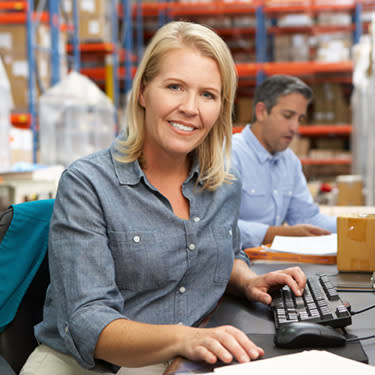 Businesswoman-working-at-desk-at-warehouse_web