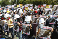 Mandalay University graduates hold posters with an image of Mya Thwate Thwate Khaing, a 19-year old woman shot by police on Feb. 9 in Naypyitaw, during an anti-coup protest in Mandalay, Myanmar, Sunday, Feb. 14, 2021. Daily mass street demonstrations in Myanmar are on their second week, with neither protesters nor the military government they seek to unseat showing any signs of backing down from confrontations. (AP Photo)