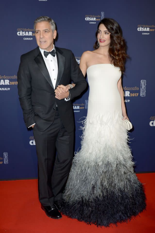 <p>Nous avons été très déçues que le couple élégant ne pose pas sur le tapis rouge des Oscars le 26 Février, mais nous leur pardonnons car ils avaient assisté à la cérémonie des Césars à Paris deux jours avant. George était très élégant dans son costume noir avec nœud papillon, et Amal était étincelante dans sa robe Atelier Versace blanche qui laissait apparaitre son petit ventre rond et dont le bas était recouvert de plumes. La perfection ! (Photo by Rindoff/Charriau/Getty Images)</p>