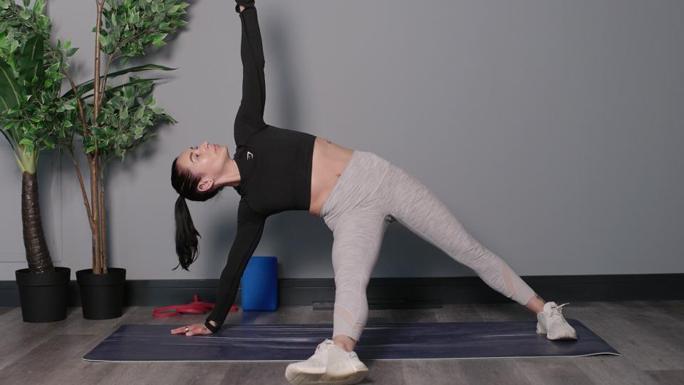 Writer Sam performing a starburst plank on yoga mat in studio