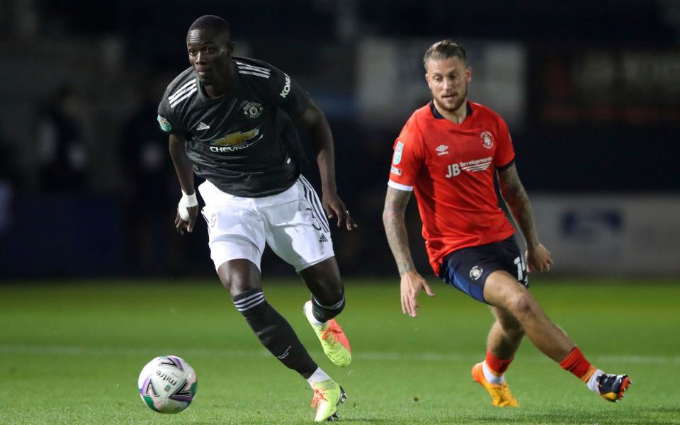 Manchester United's Eric Bailly, left, runs with the ball past Luton Town's George Moncur  - PA