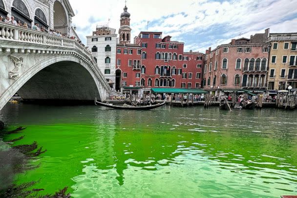 PHOTO: Gondolas navigate by the Rialto Bridge on Venice's historical Grand Canal as a patch of phosphorescent green liquid spreads in it, May 28, 2023, in Venice, Italy. (Luigi Costantini/AP)