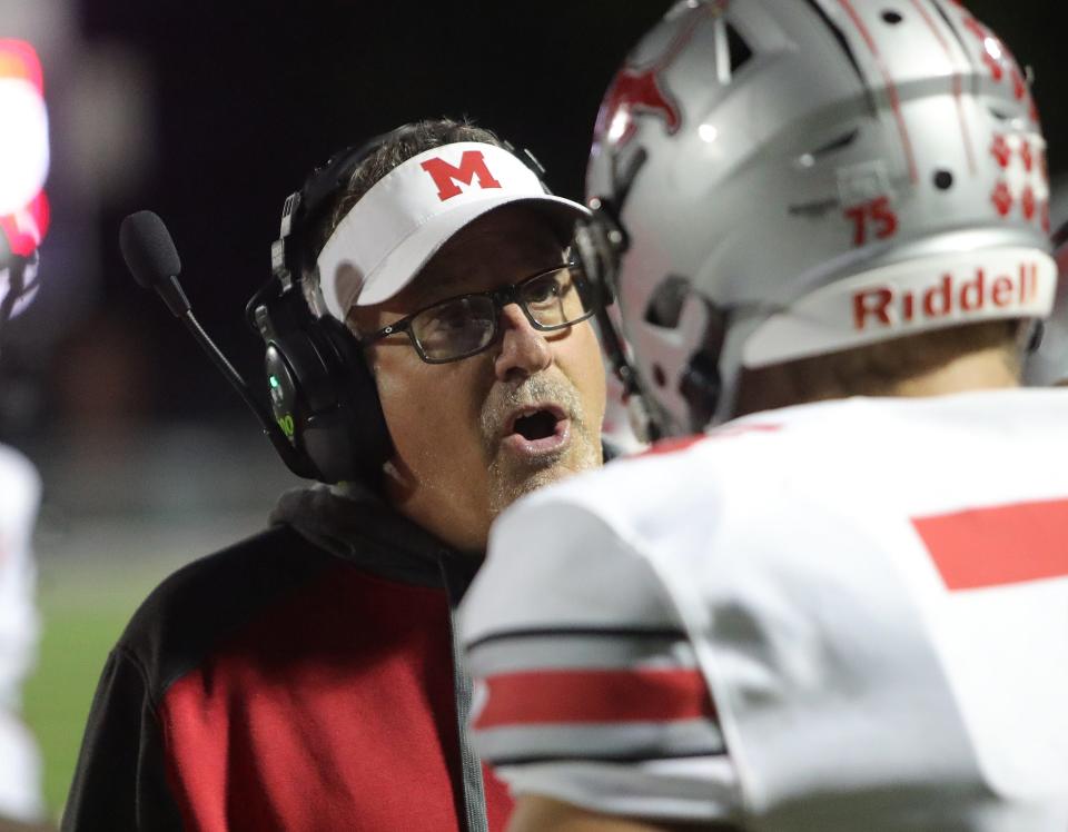 Minerva football head coach Tim Speakman speaks to a lineman at Kehres Stadium, Friday, Oct. 13, 2023.