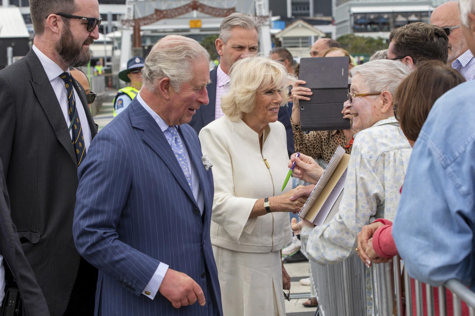 Britain's Prince Charles, second left, and his wife Camilla, center, greet members of the public during a walk at Viaduct Harbour in Auckland during their royal visit to New Zealand, Tuesday, Nov. 19, 2019. The visit is part of a week-long tour of the country which also takes in Christchurch and Kaikoura. (David Rowland/Pool Photo via AP)