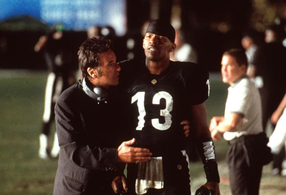 a photo from the film any given sunday, with al pacino speaking to jamie foxx on a football field, with foxx wearing a football uniform
