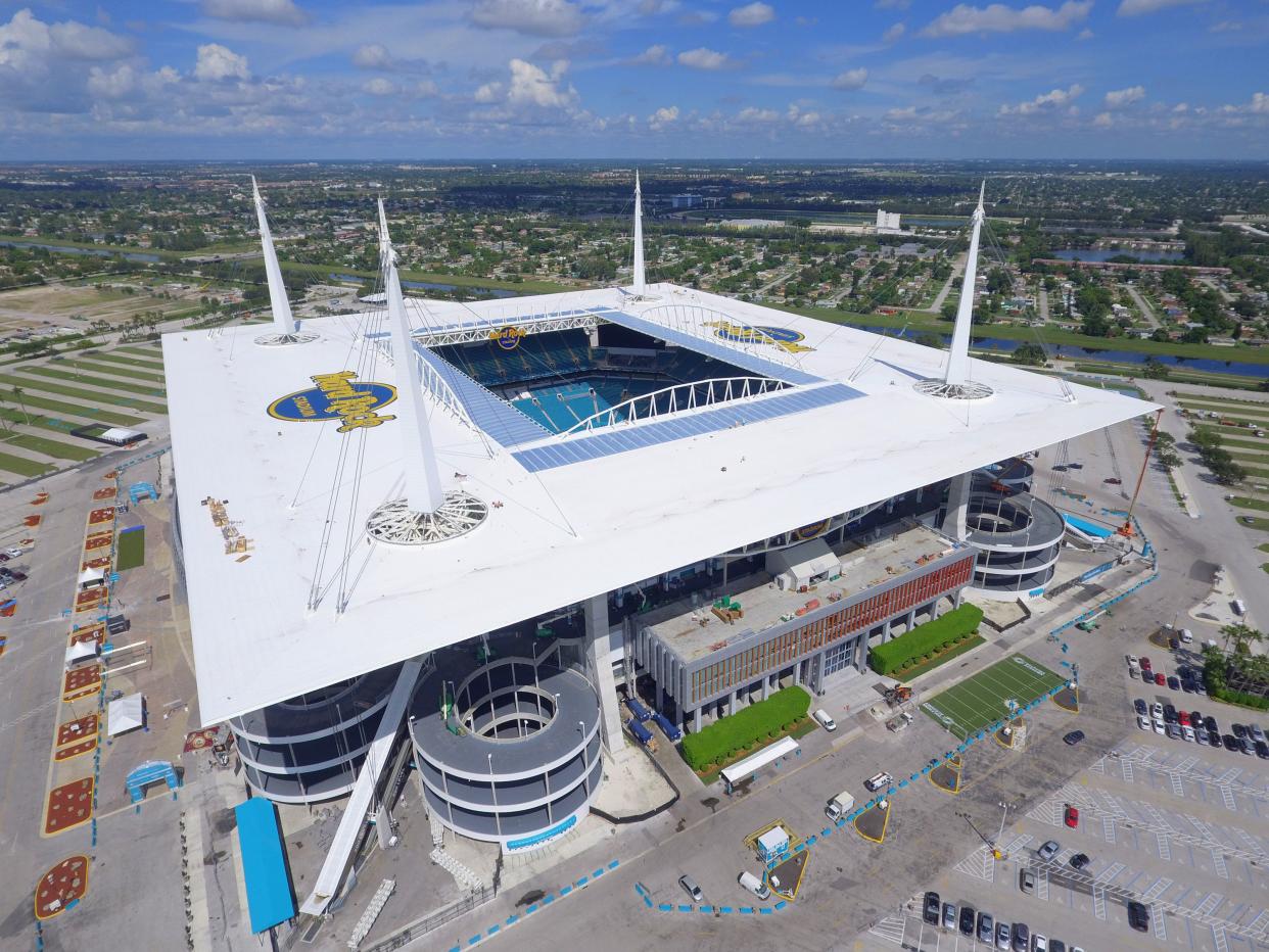 Aerial of Miami Dolphins, Hard Rock Stadium, Miami, opened and empty field surrounded by an empty parking lot with several subdivisions and the city in the background