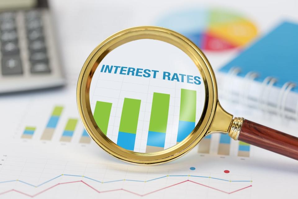 Magnifying glass zooming in on interest rates chart.