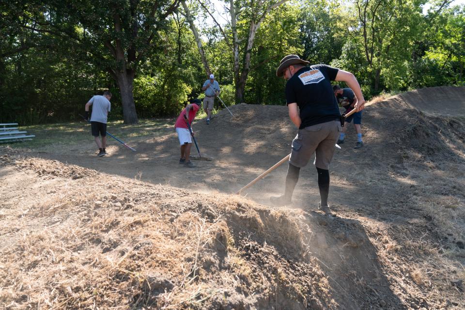 Volunteers rake away debris from the Heartland BMX Track on Sept. 2 as the facility prepares to become operational for next year's season of BMX racing.