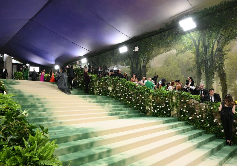 The Met Museum steps are covered in green and tan carpet and foliage for the 2023 Met Gala.