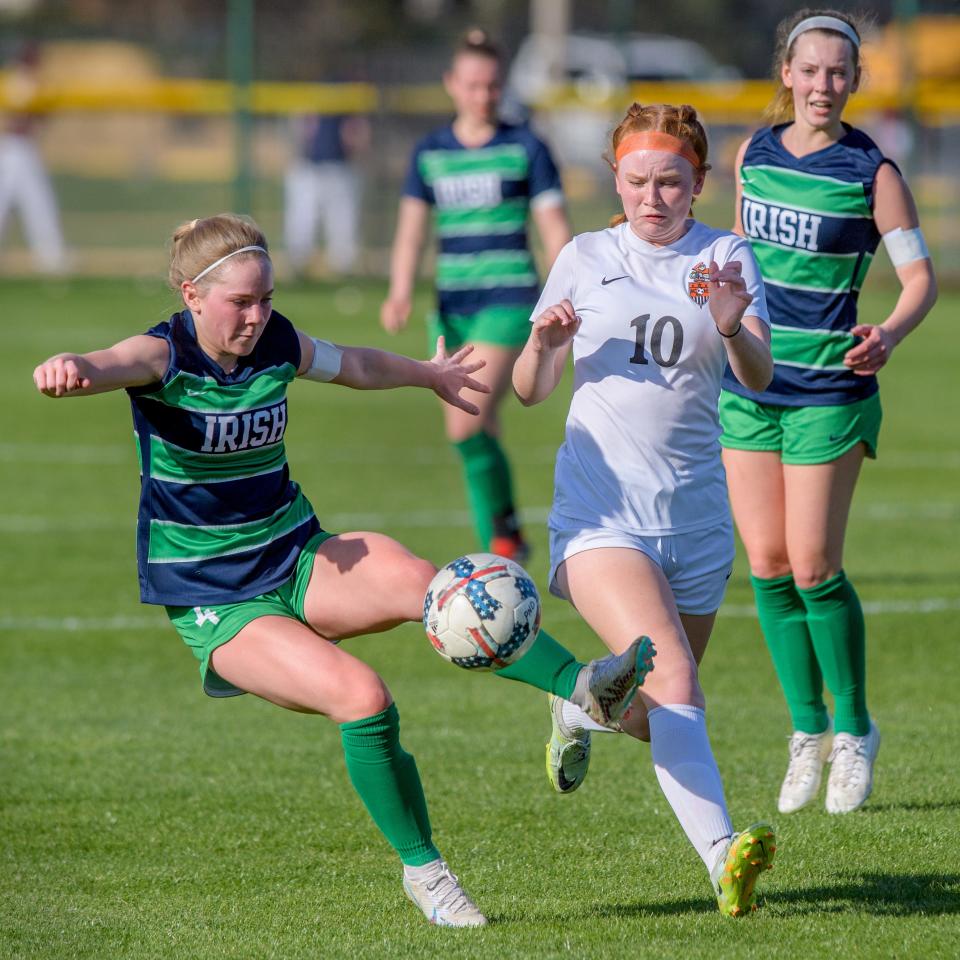 Peoria Notre Dame's Ellen Dahlquist, left, plays the ball against Normal Community's Reese Anderson in the first period Thursday, April 13, 2023 at PND High School. The Irish blanked the Ironmen 2-0.