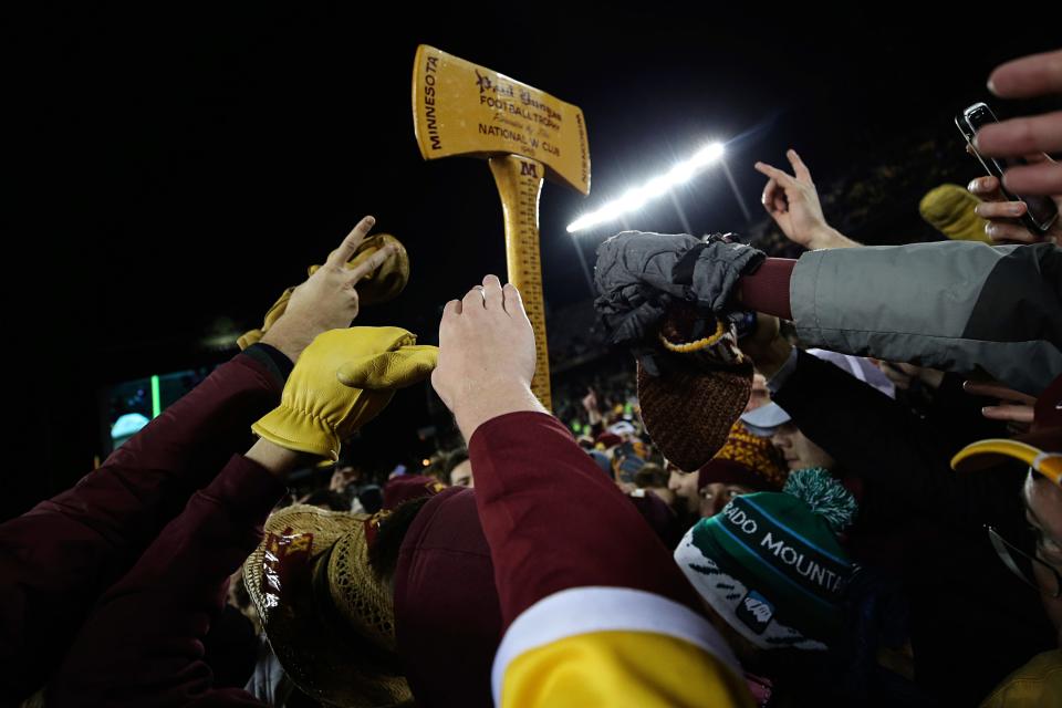 Minnesota fans reach up toward Paul Bunyan's Ax after Minnesota defeated Wisconsin in an NCAA college football game Saturday, Nov. 27, 2021, in Minneapolis.