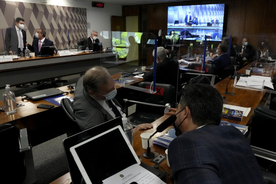 Senators talk during a session by their commission investigating the government's management of the COVID-19 pandemic at the Federal Senate in Brasilia, Brazil, Tuesday, Oct. 26, 2021. (AP Photo/Eraldo Peres)