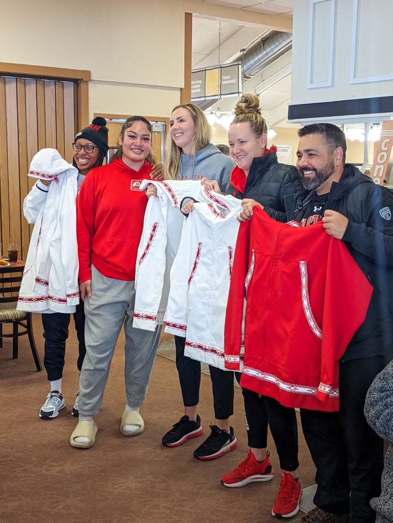 All-American Alissa Pili, second from left, with the Utah coaching staff, showing off the jackets that Pili's grandmother handmade for them.